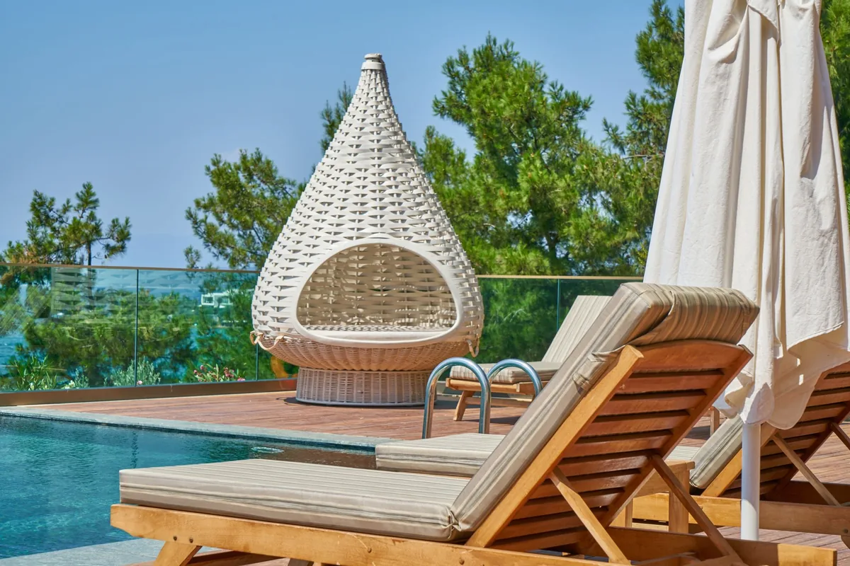 Hotel outdoor tropical pool deck with lounge chairs