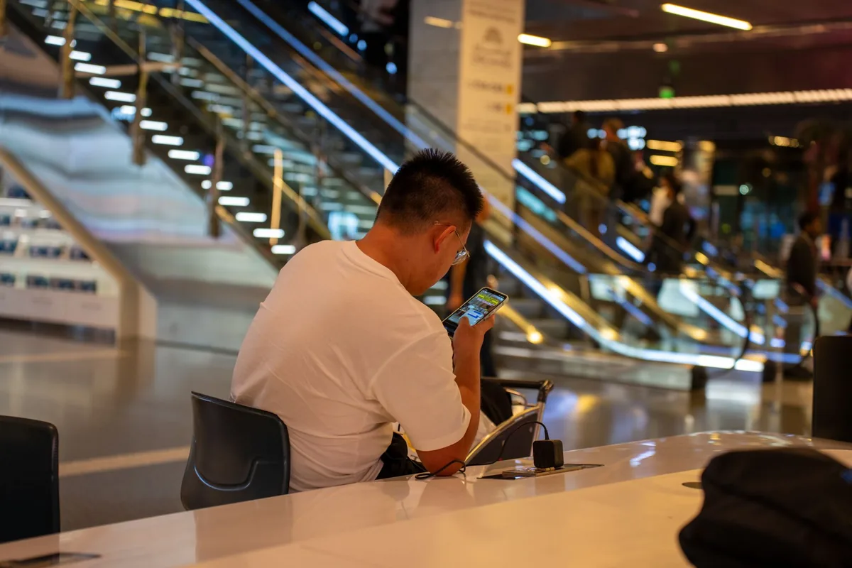 business traveler looking at smartphone in airport