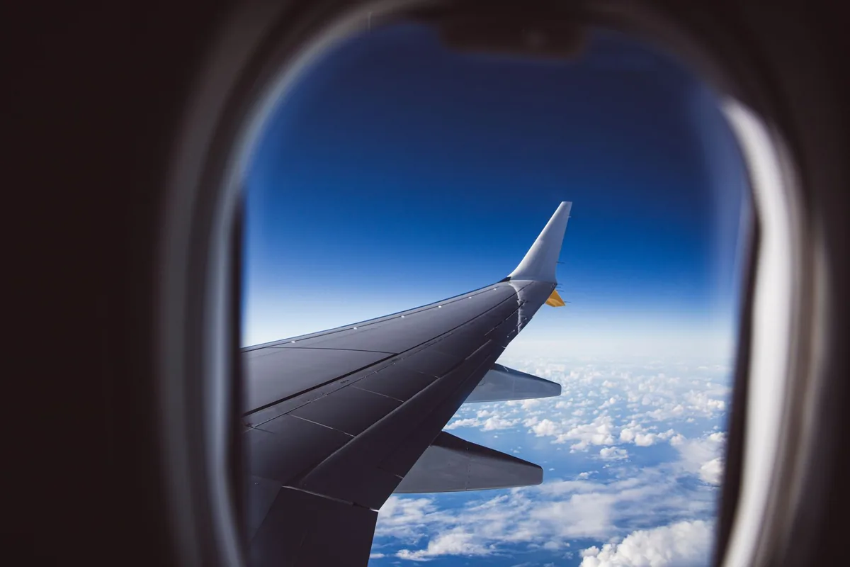 commercial aircraft flying above clouds