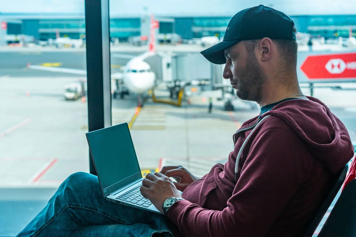 corporate traveler working on laptop in airport lounge
