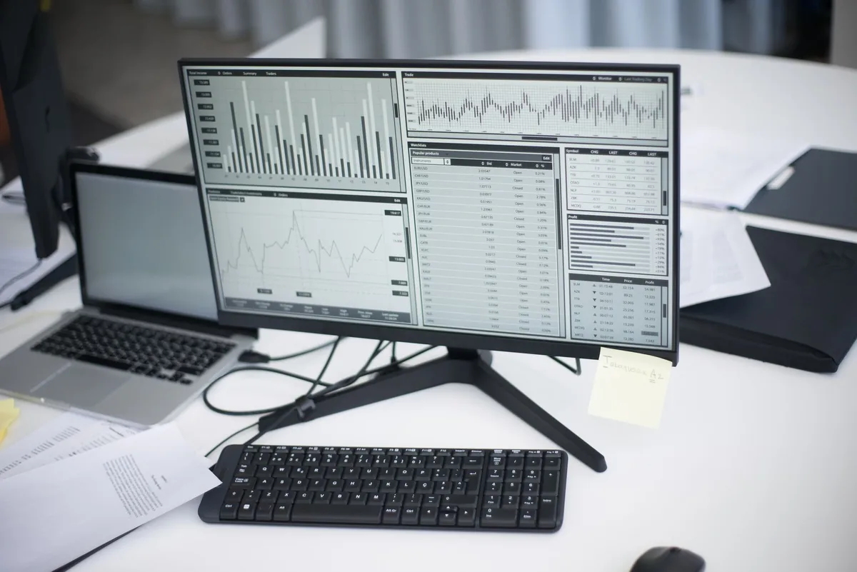 financial charts displayed on a computer screen in an office