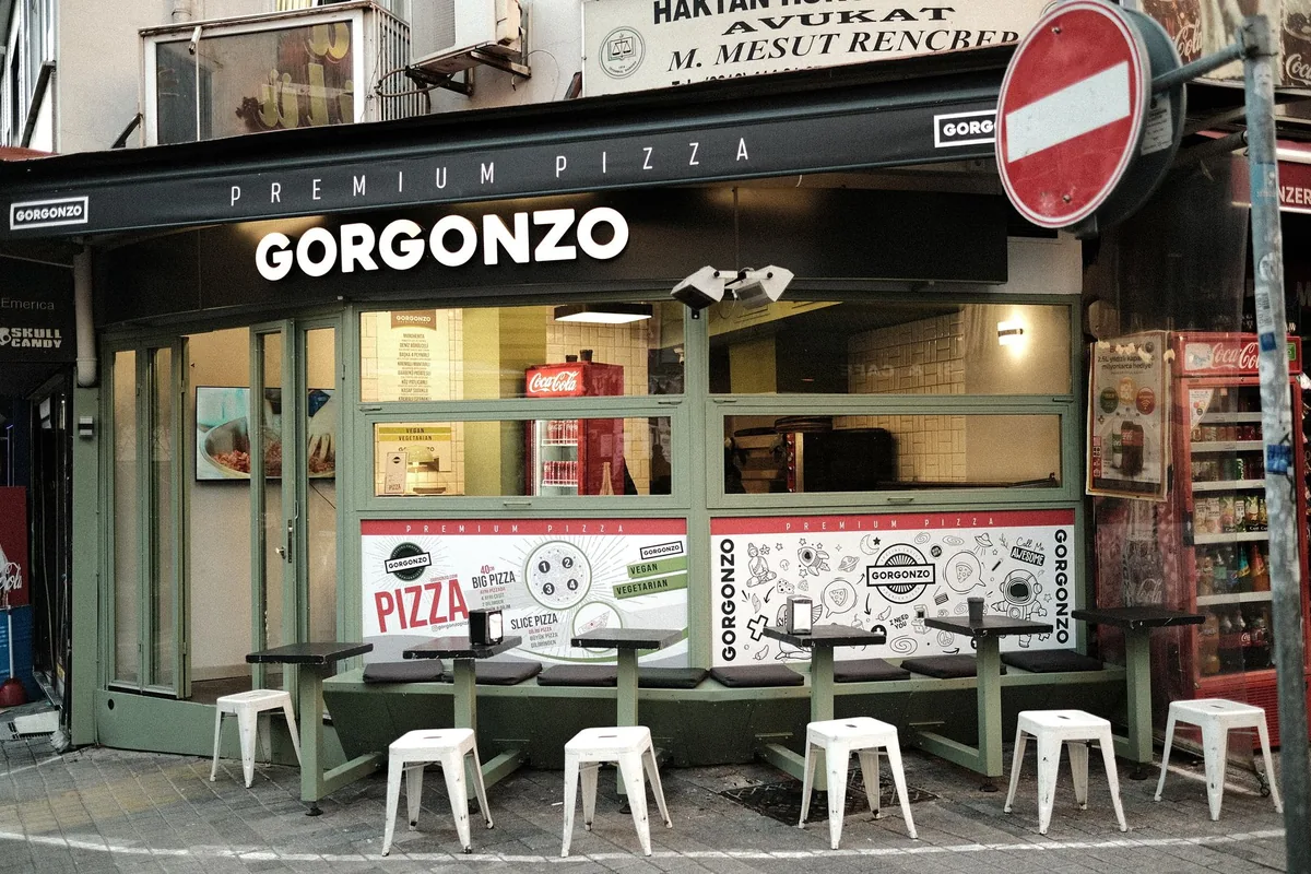 restaurant exterior with dining tables and signage