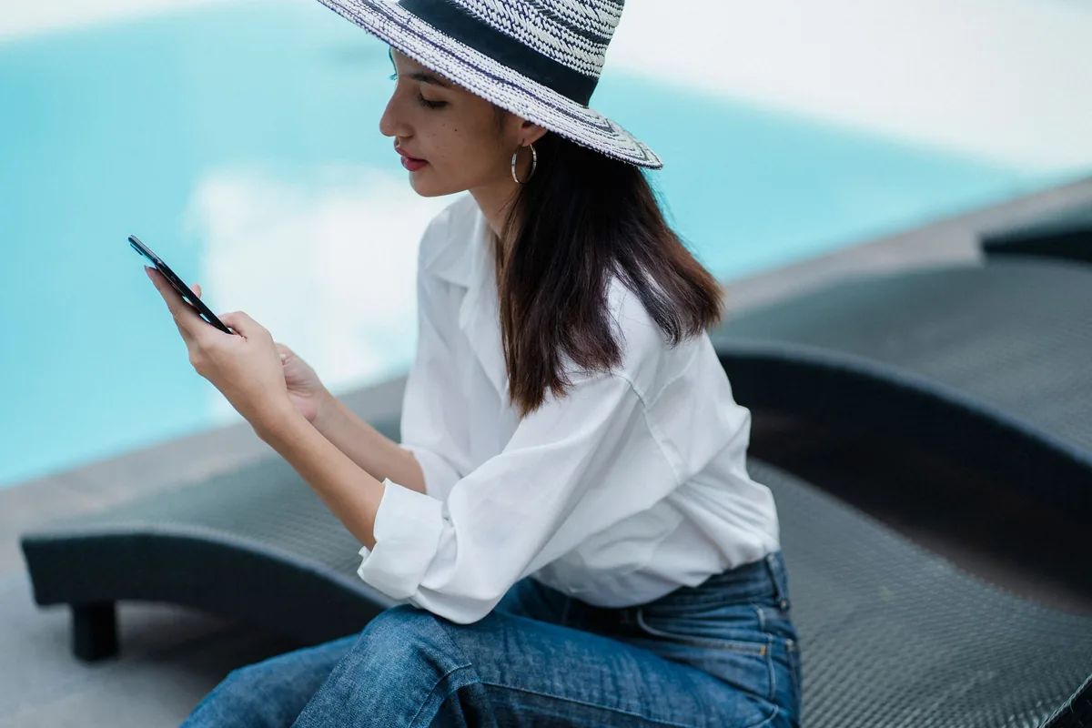 guest using smartphone poolside lounge chair