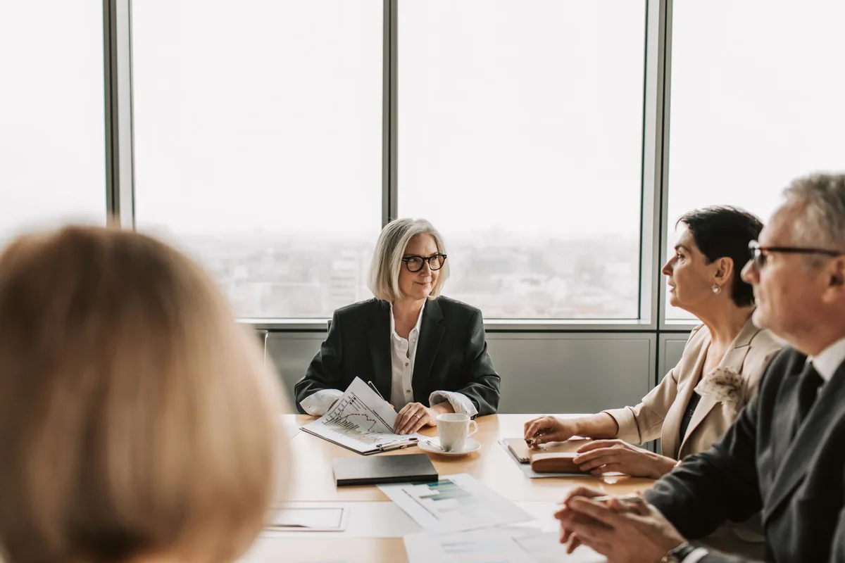 corporate executives meeting glass boardroom