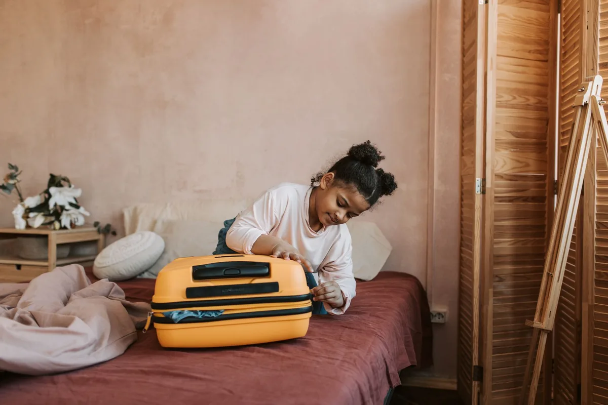 traveler packing luggage near bed
