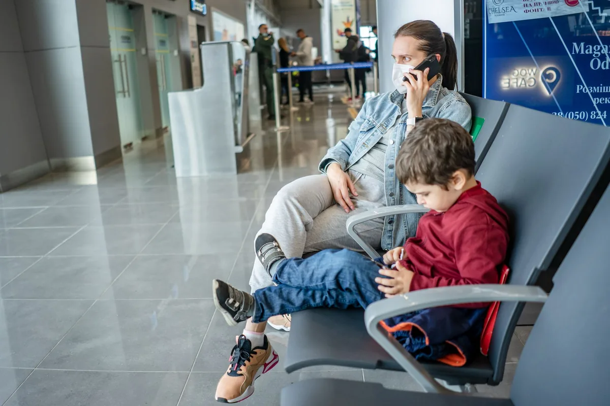 traveler using mobile phone at airport departure gate