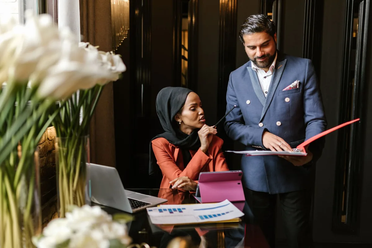 hotel general manager reviewing tablet at reception desk