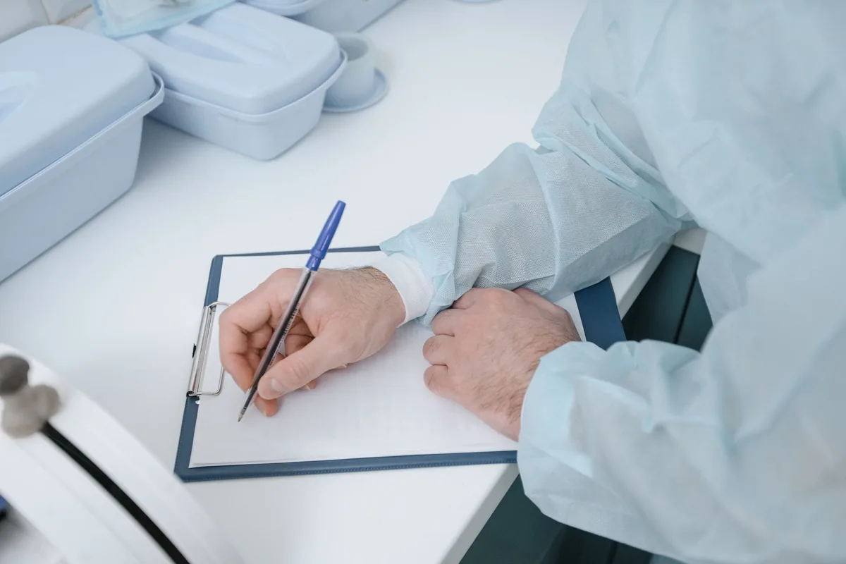 hotel worker writing paper notes spreadsheet