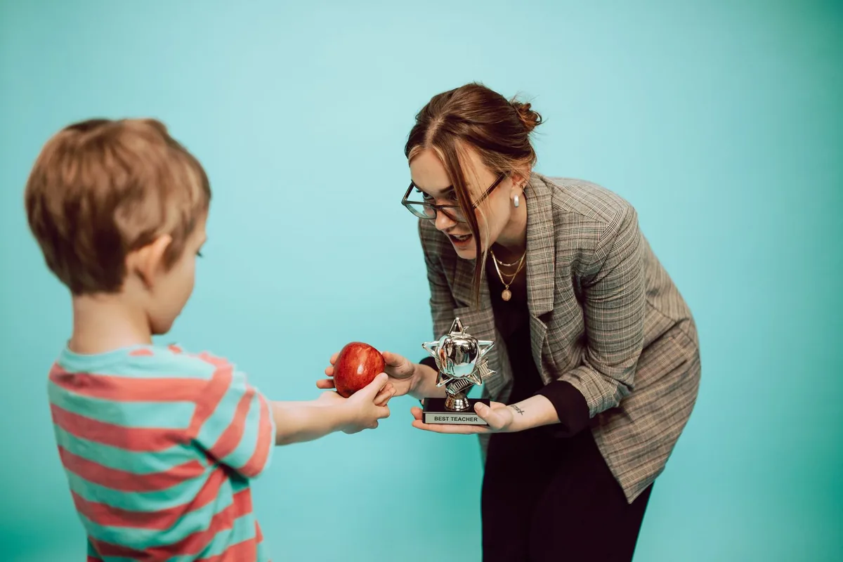 speaker at a podium handing a glass award trophy to a smiling recipient