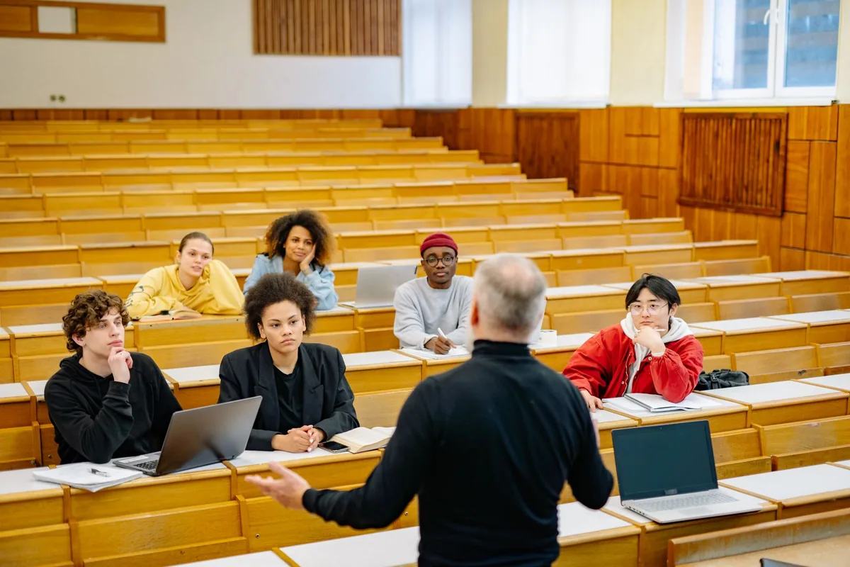 students sitting in a modern university lecture hall taking notes