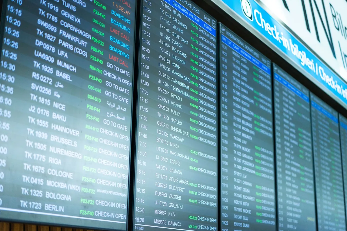 airport departure board showing flight times and destinations