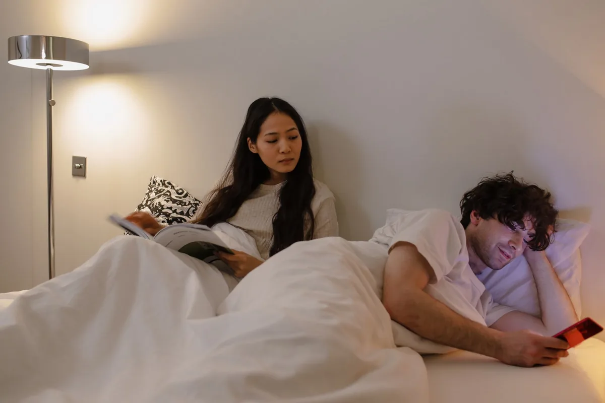 traveler browsing smartphone in modern hotel bedroom