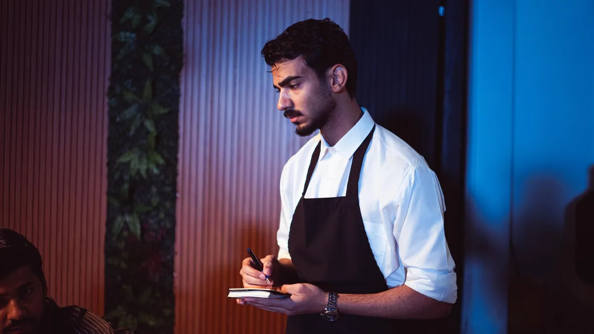 waiter holding digital tablet in dining room