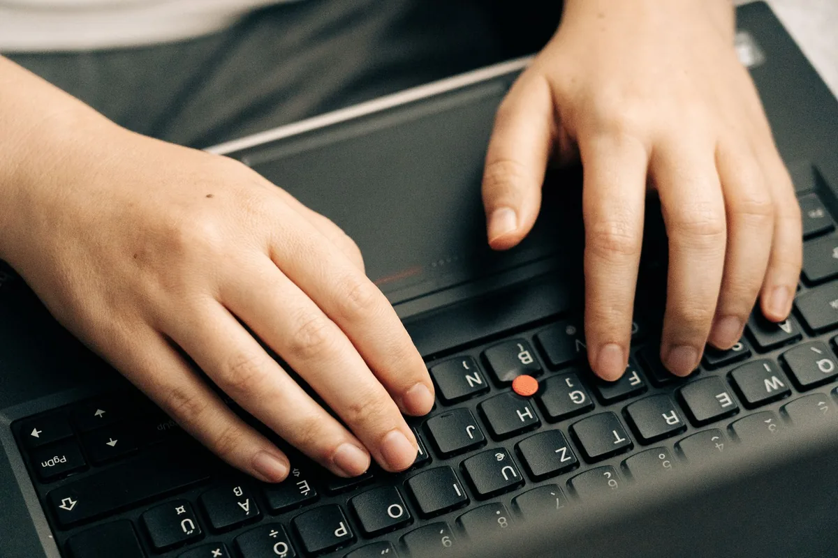 person typing on laptop keyboard