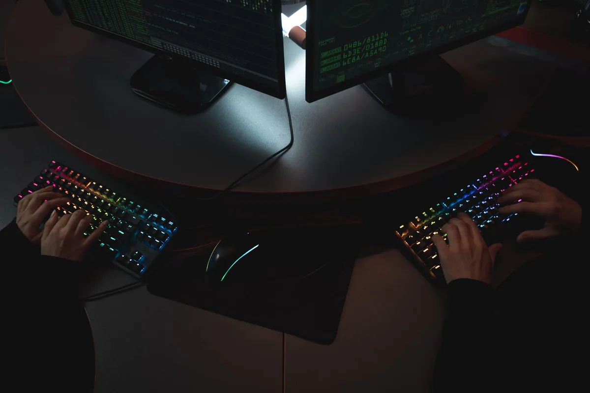 software developer writing code at dual monitors