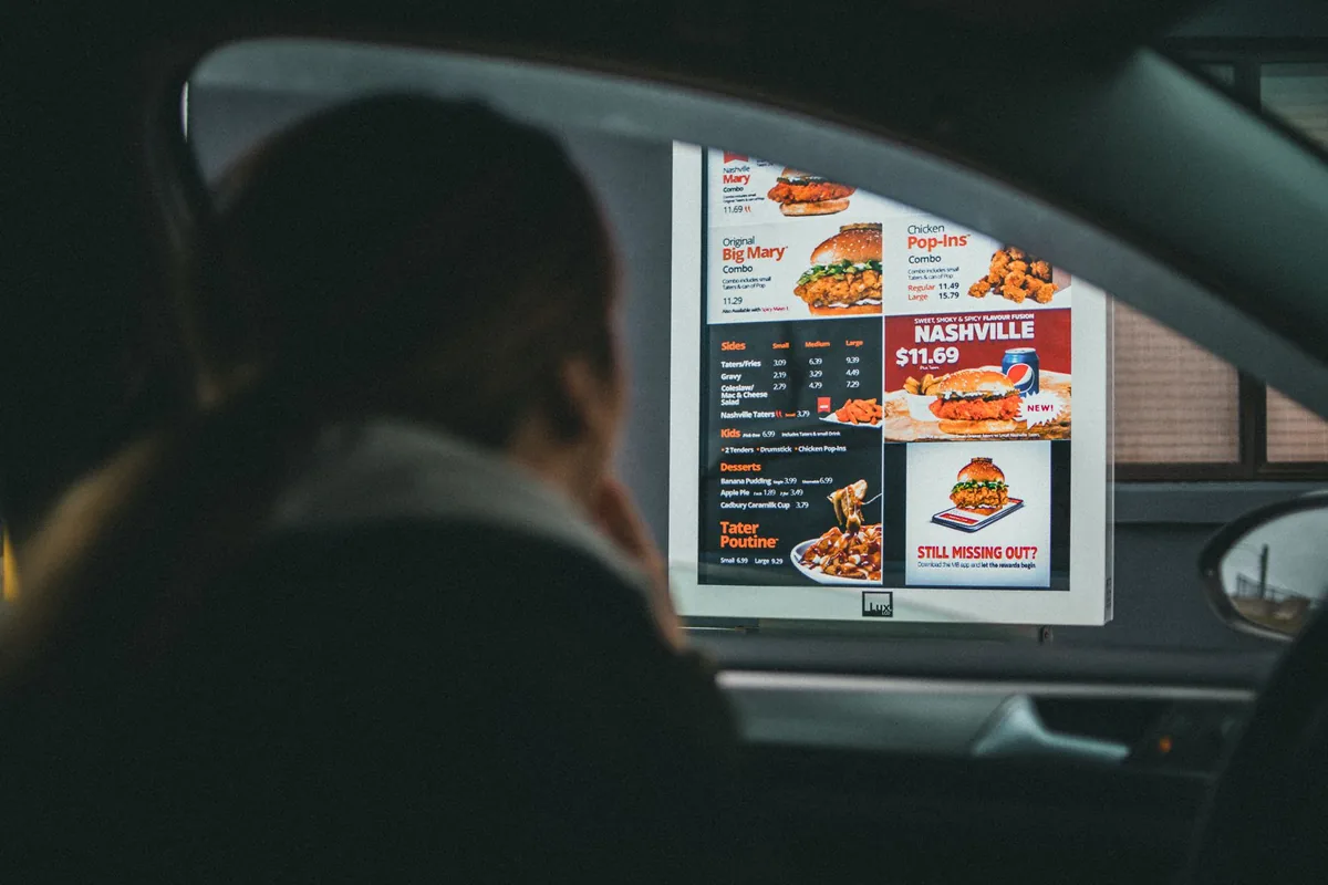 drive-thru coffee menu board with cars in line