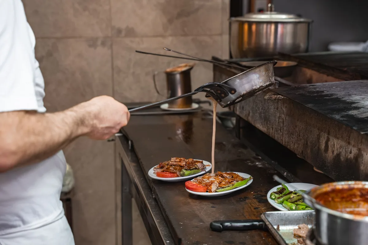 chefs plating multi course dinner in commercial kitchen