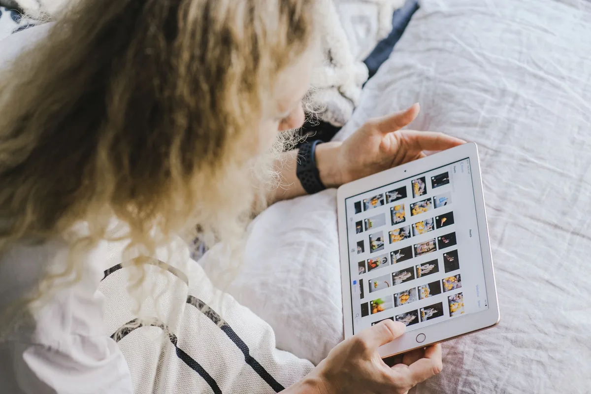 traveler browsing tablet on luxury hotel bed