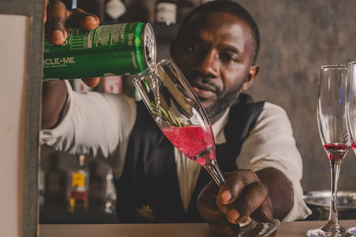 bartender pouring champagne into glass at hotel bar