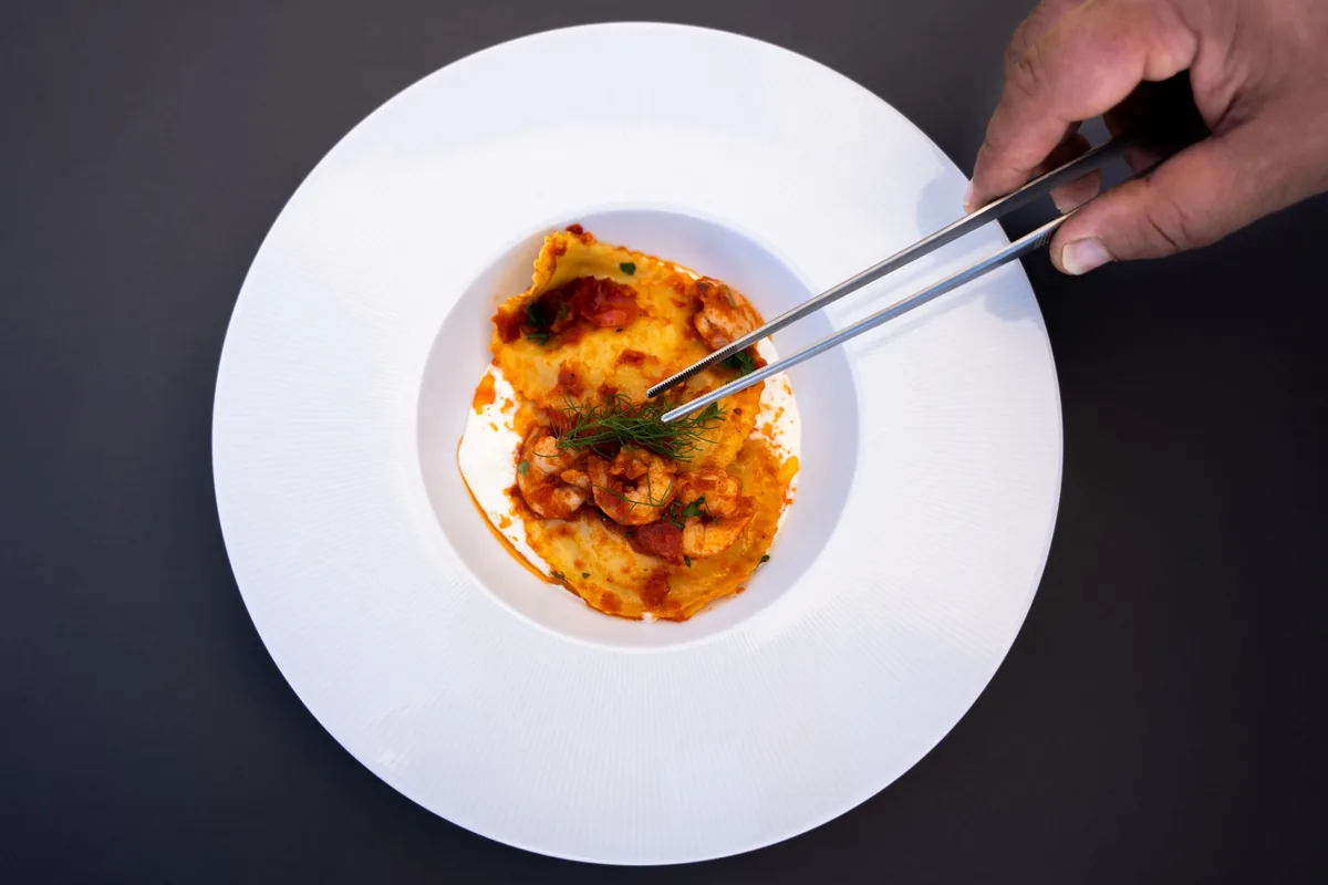 chef plating dish with tweezers