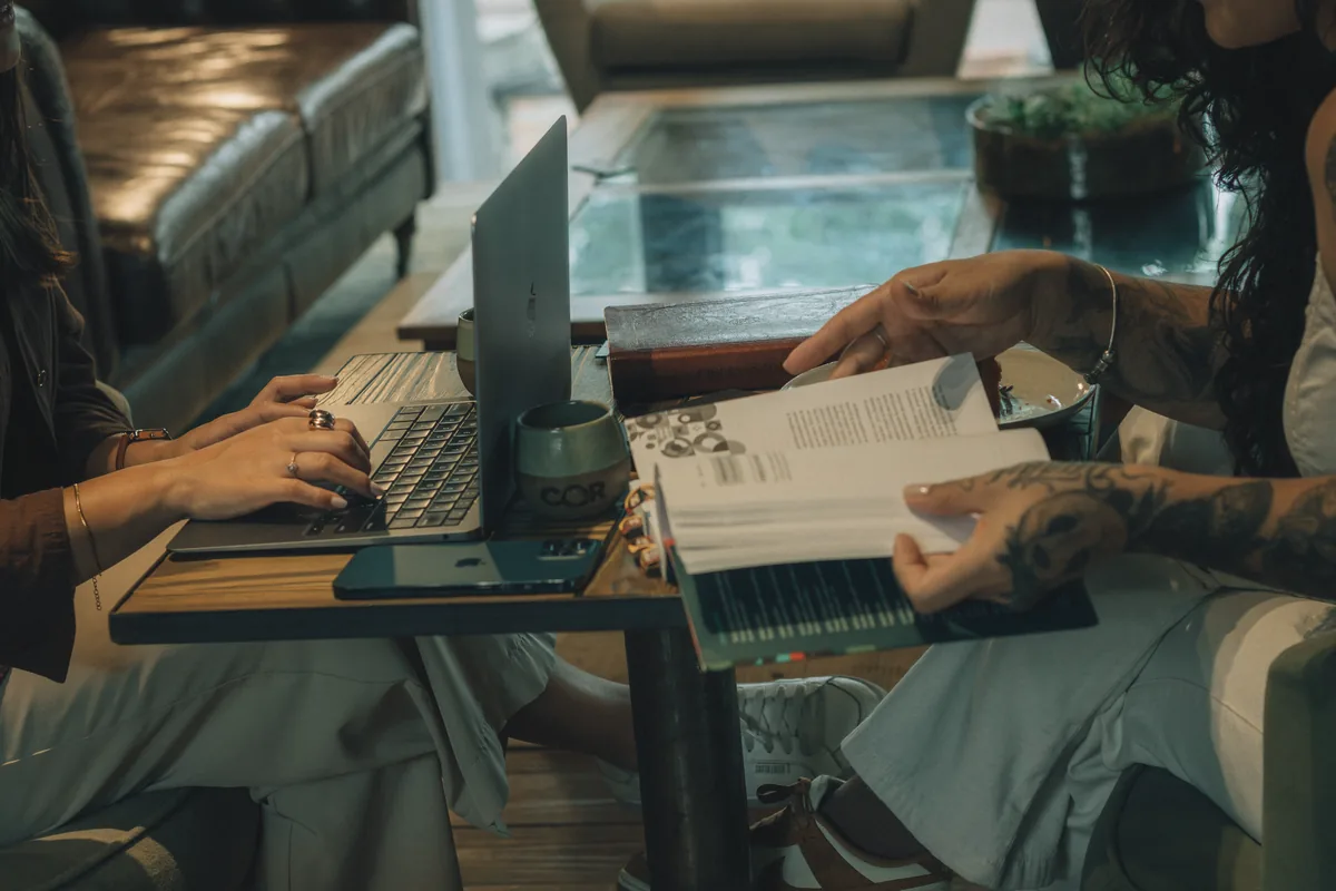 communal table in a hotel lounge with laptops and coffee cups