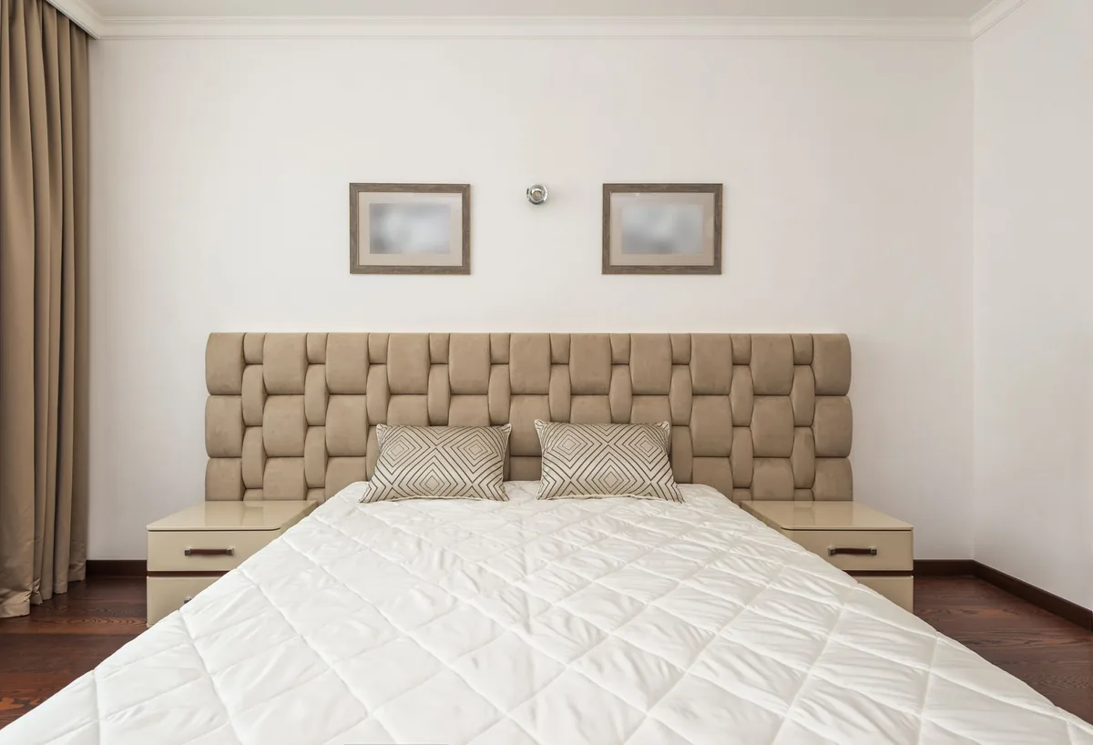 upholstered headboard and wood nightstands in a luxury hotel room
