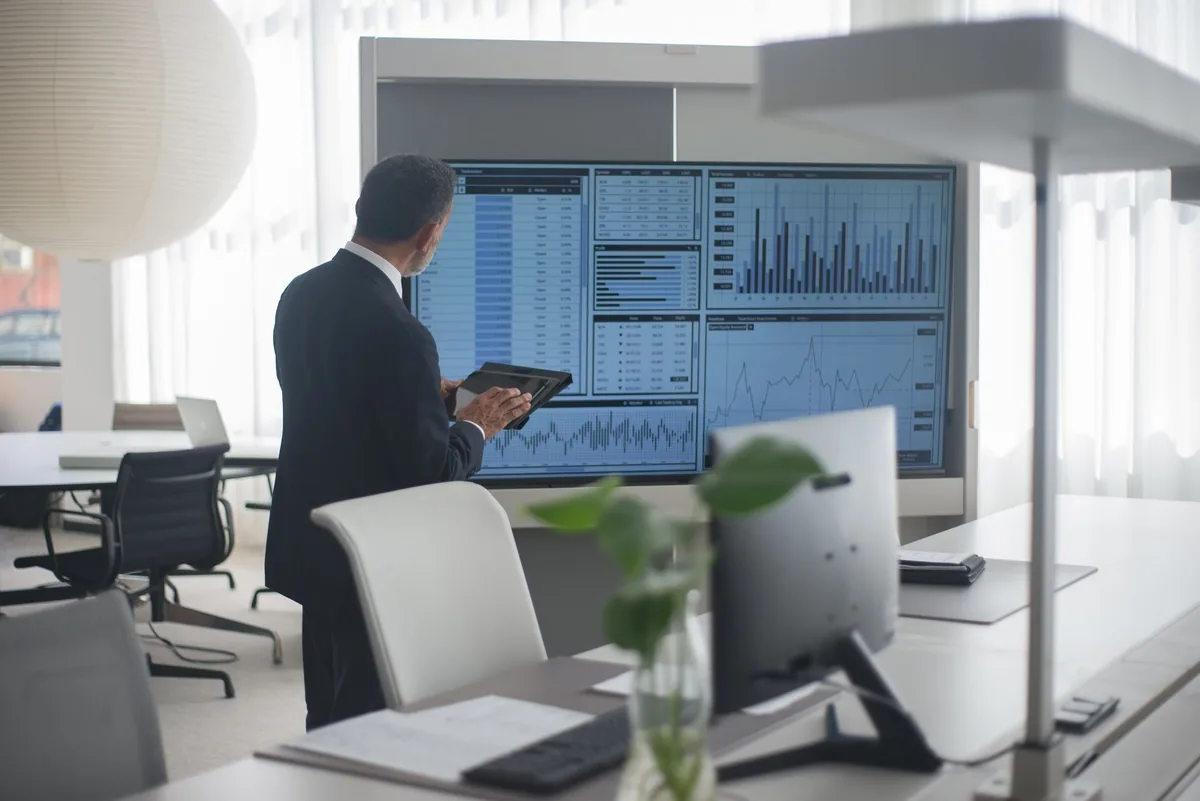 hotel executive reviewing financial charts on a tablet in a boardroom