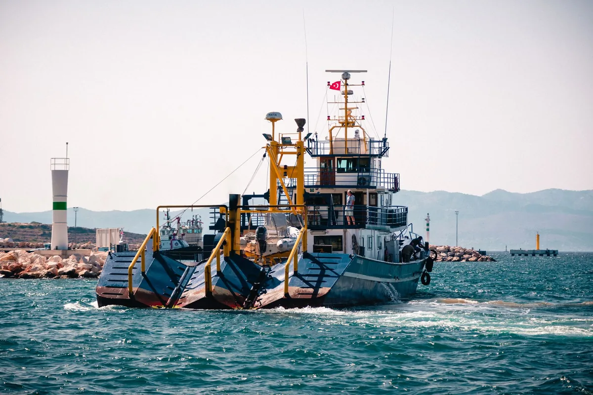 specialized boat dredging seaweed from the ocean water