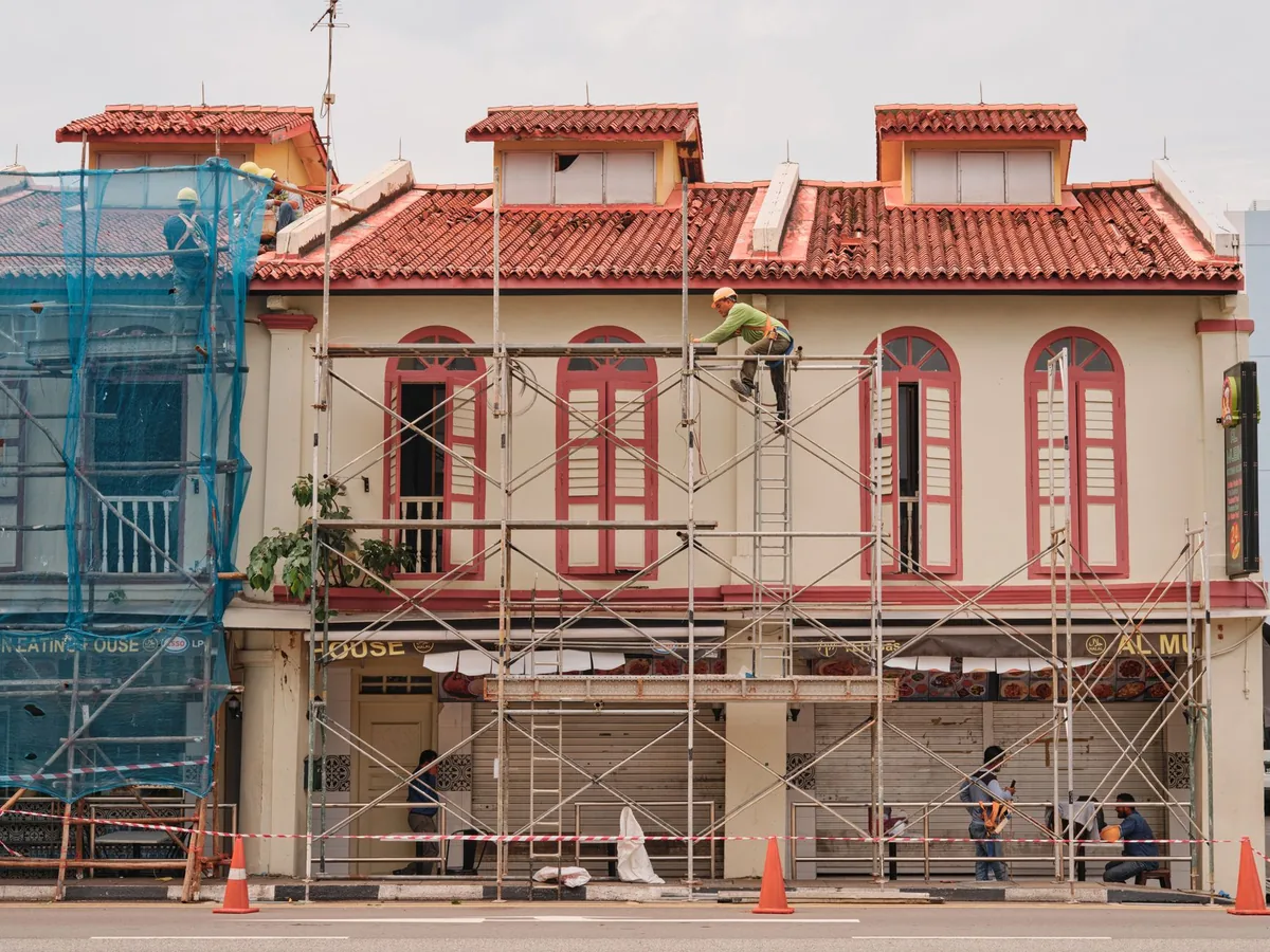 construction workers on scaffolding renovating a historic hotel facade