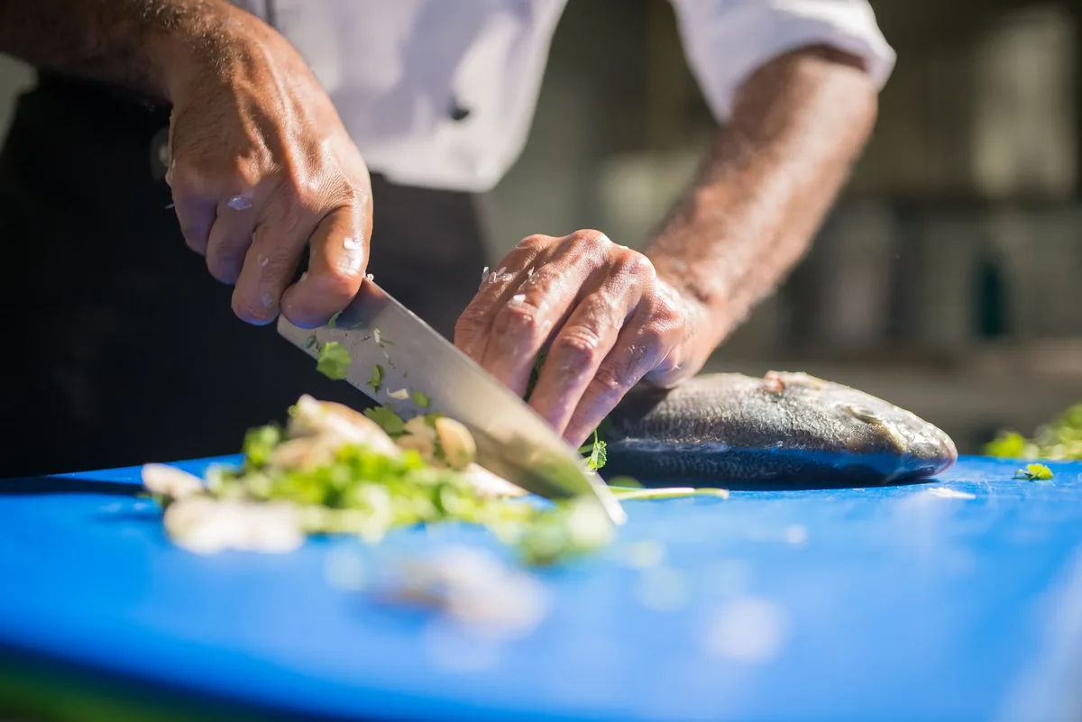 hotel kitchen chef preparing seafood dish
