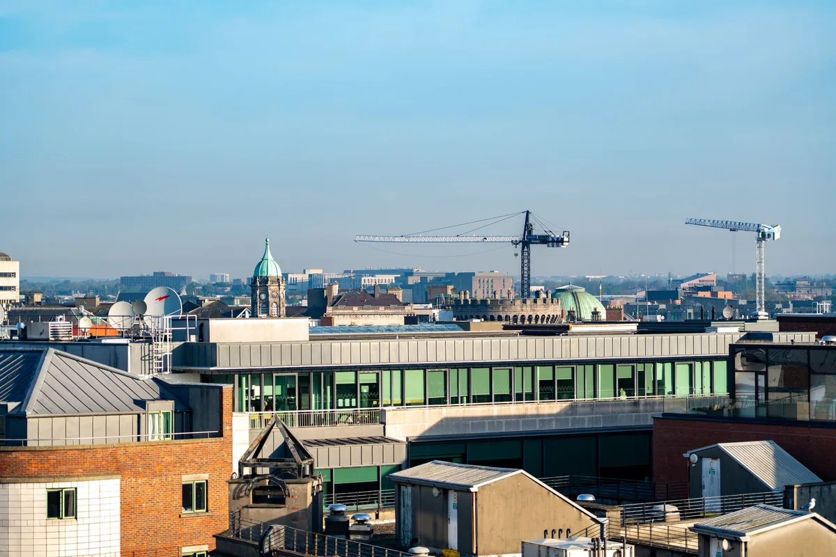 city skyline with construction cranes