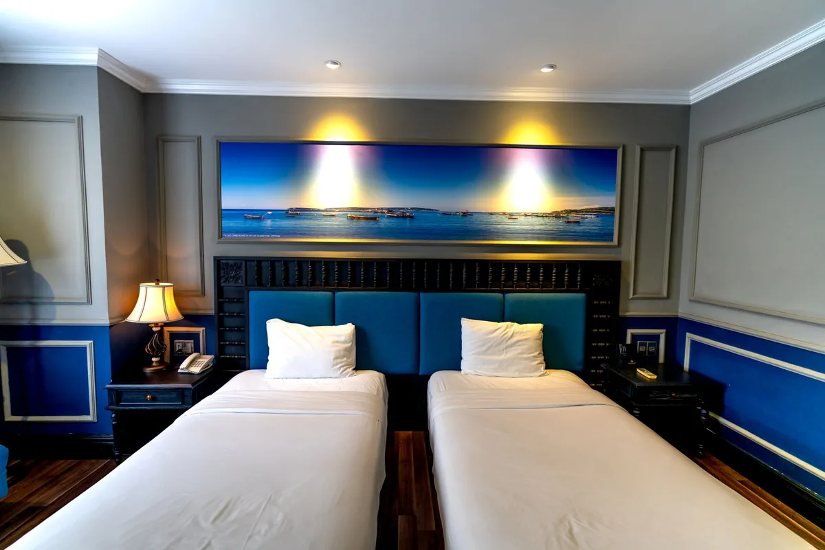 hotel guest room with blue and green color palette and maple leaf headboard