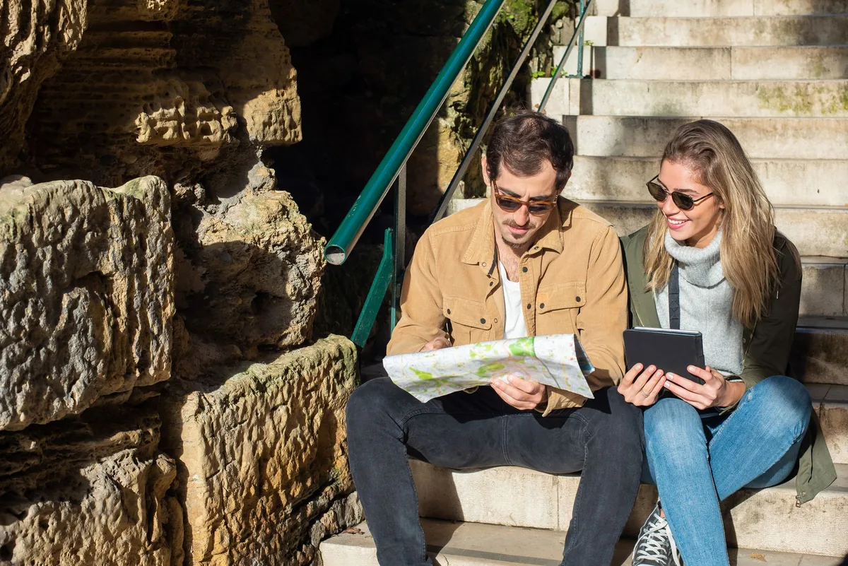 traveler looking at a digital map on a tablet outside a modern hotel entrance