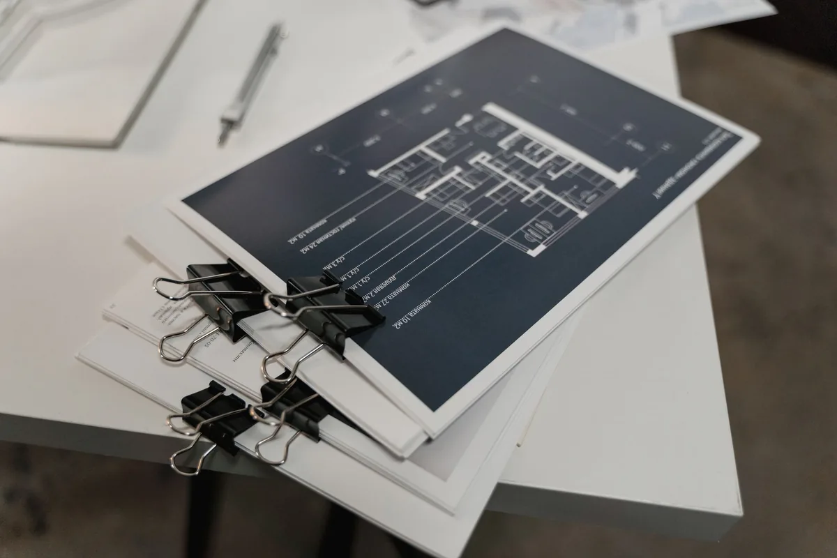 financial documents and architectural blueprints on a desk