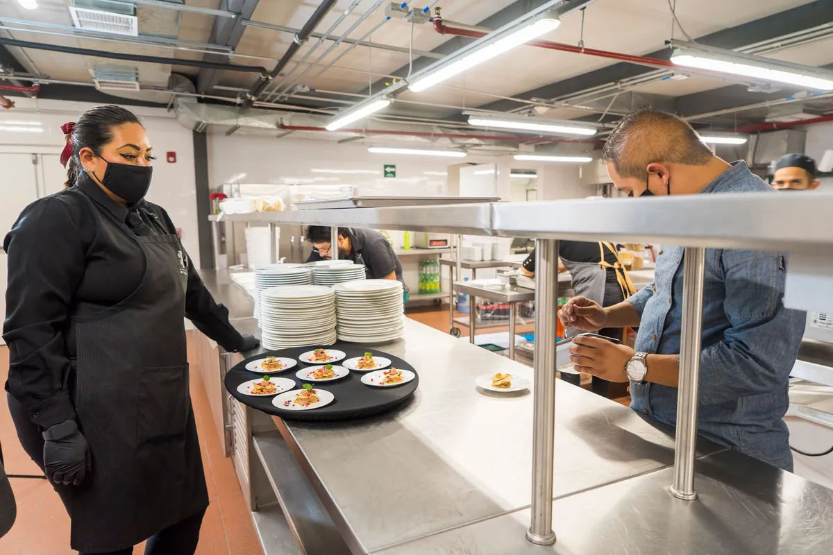 chef plating food in commercial restaurant kitchen