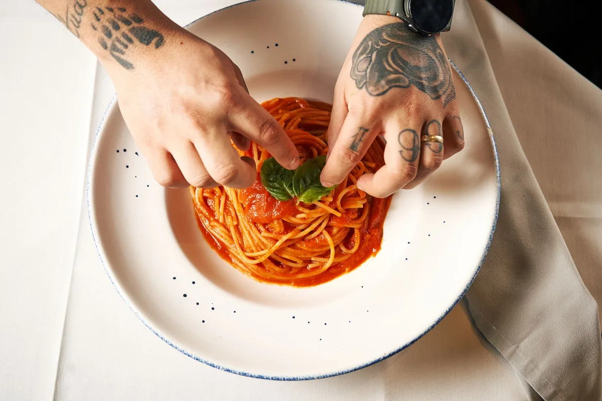 chef plating fresh pasta kitchen