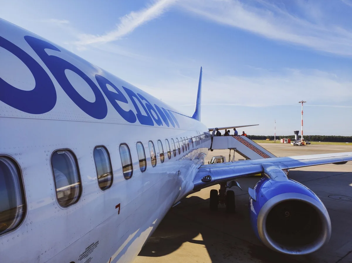 airplane on airport tarmac boarding passengers