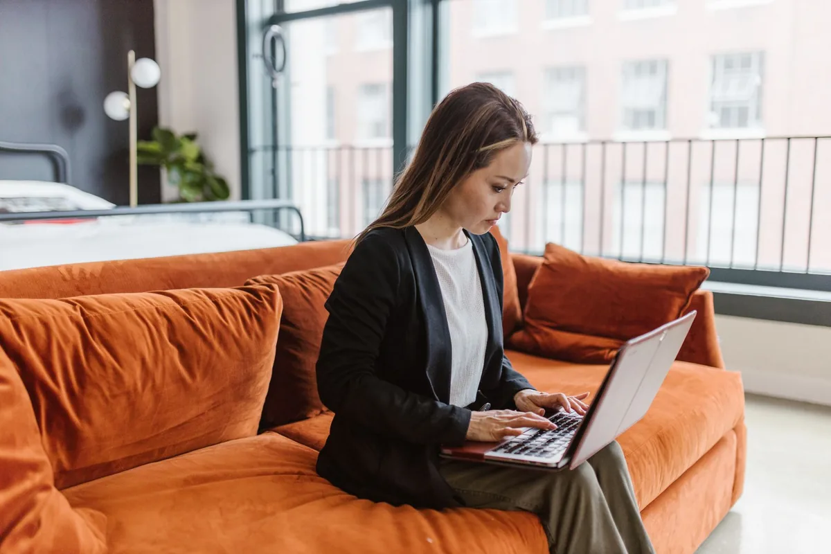 business traveller typing on laptop in apartment
