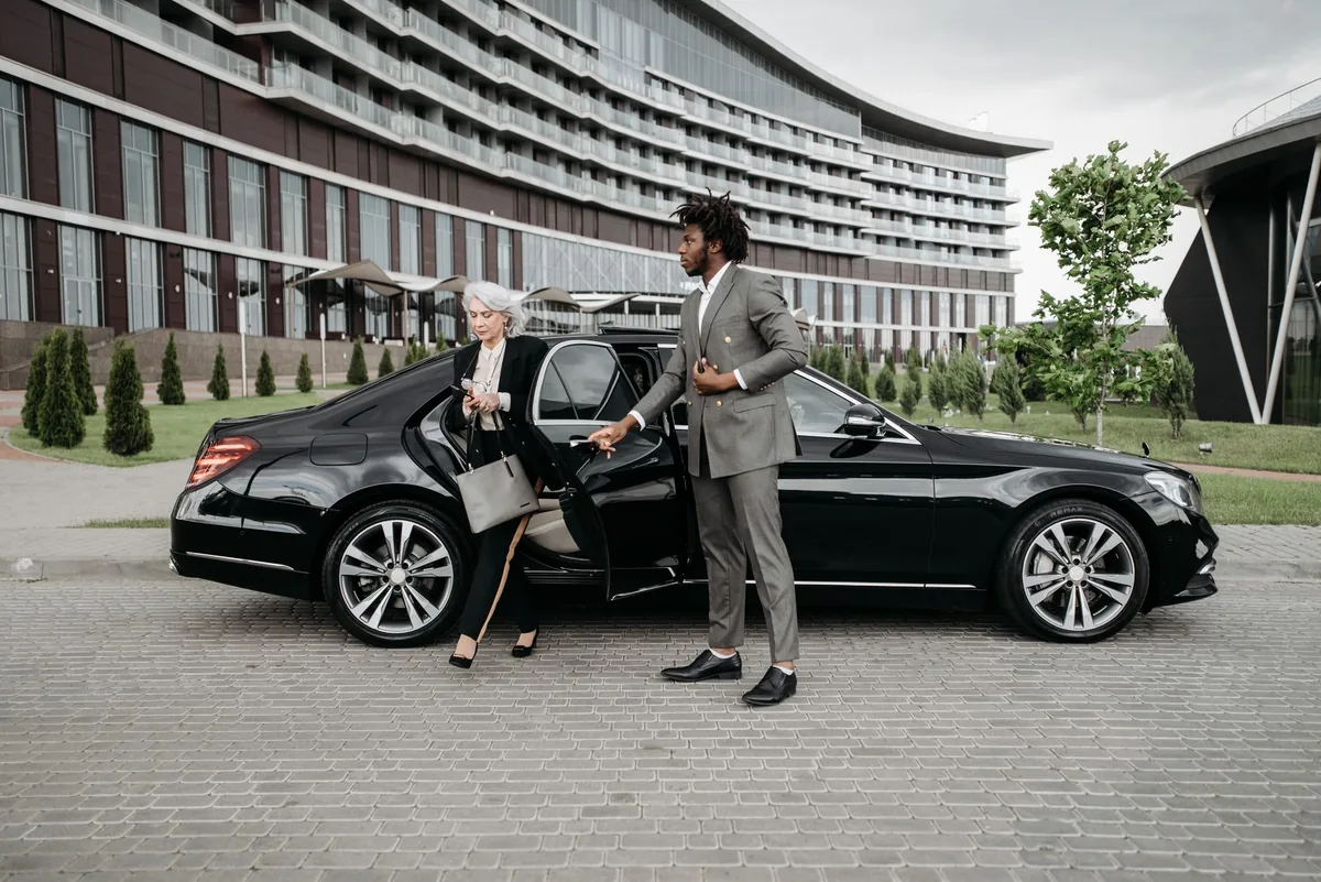 business traveler exiting car outside hotel entrance