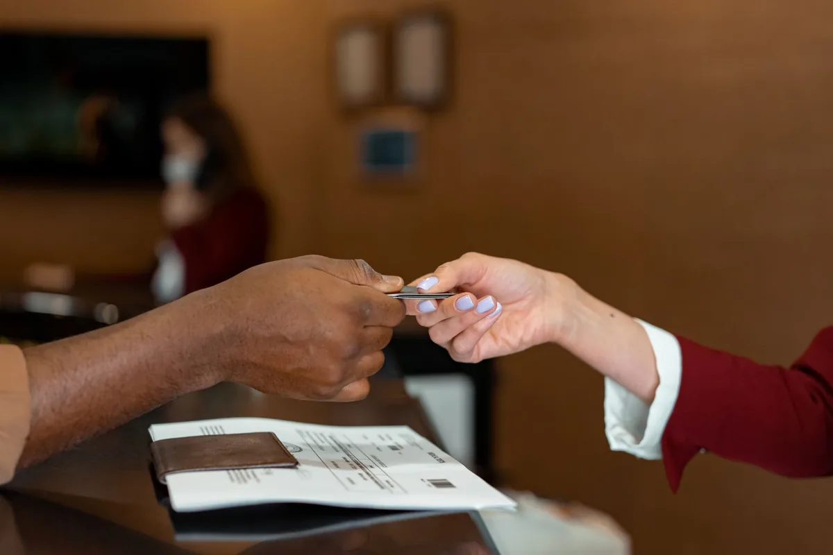 close up of a hotel guest paying at a reception desk