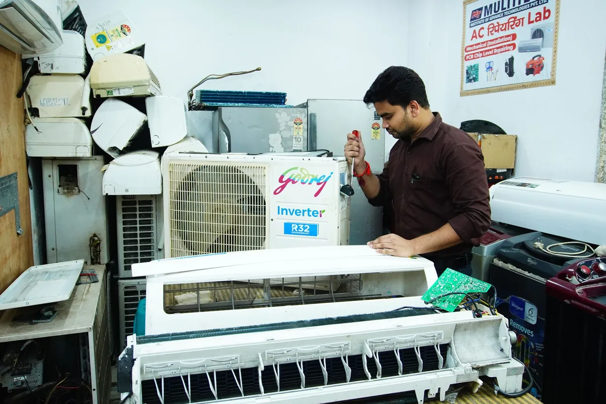 hotel maintenance technician repairing air conditioner
