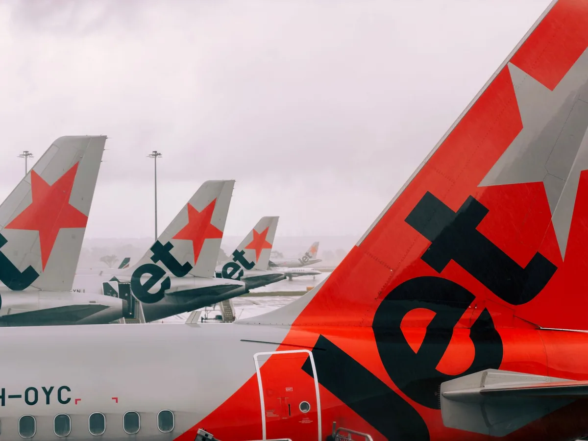 commercial aircraft tail fins lined up runway