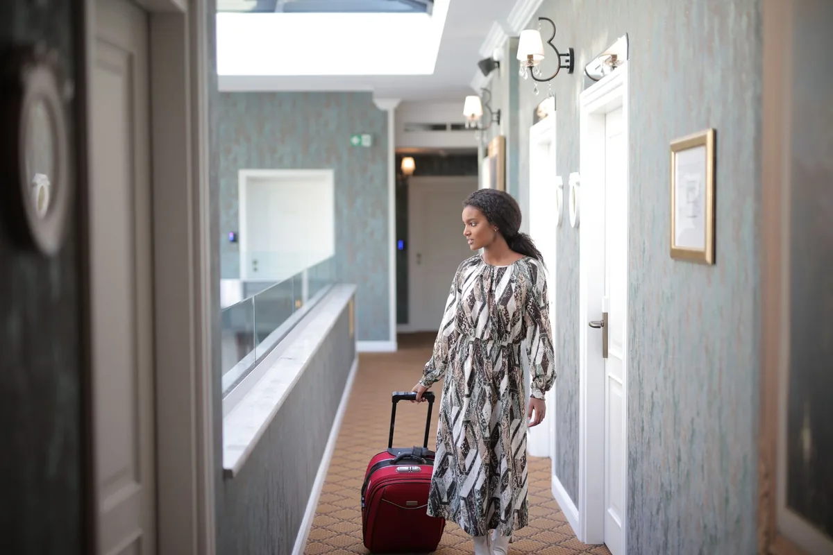 hotel manager walking through modern guest room corridor